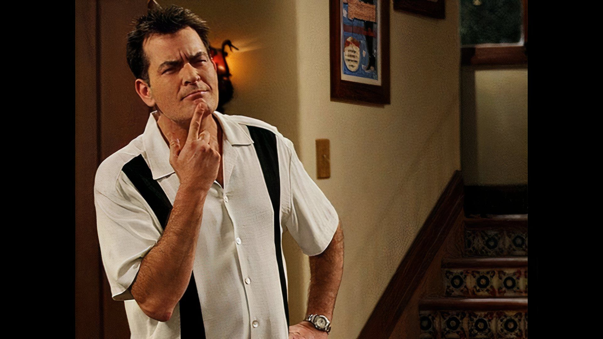 Sheen as Charlie Harper on Two and a Half Men with his hand on his chin