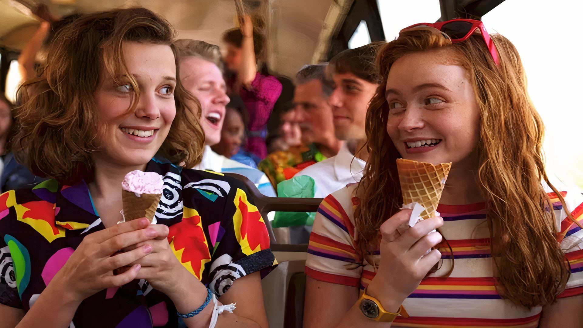 Stranger Things with Sadie Sink as Max and Millie Bobby Brown as Eleven eating ice cream on a bus