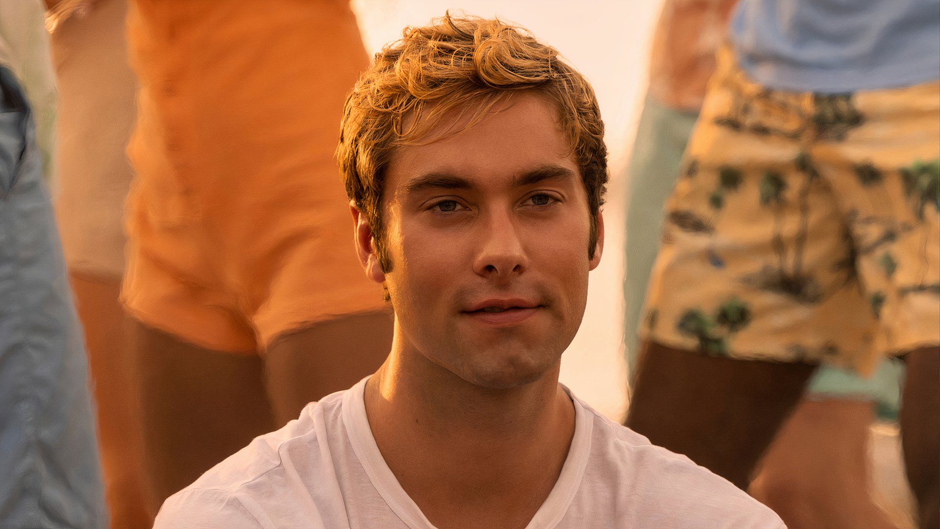 Austin North as Topper in Outer Banks smiling while people stand around him