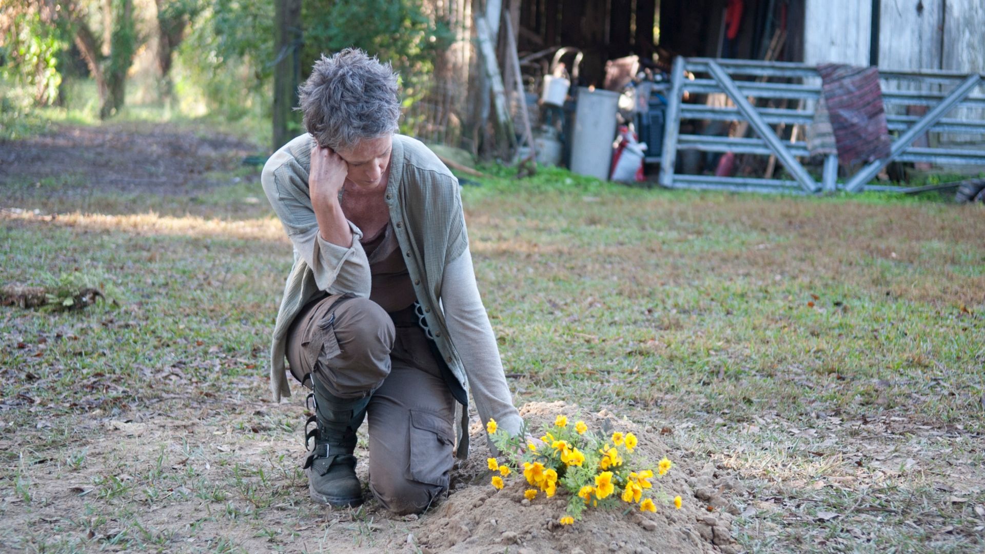 Carol kneels by a grave in The Walking Dead