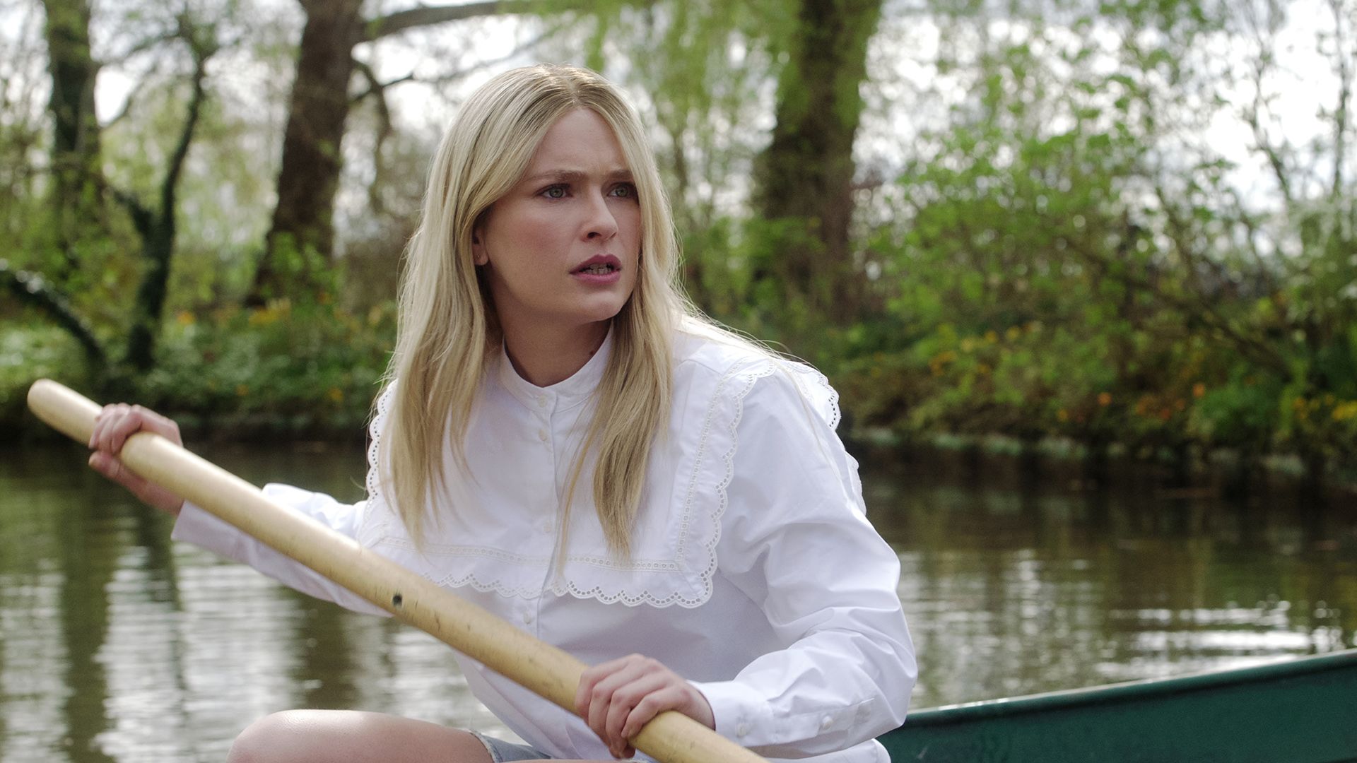 Camille on a boat rowing looking angry on Emily in Paris