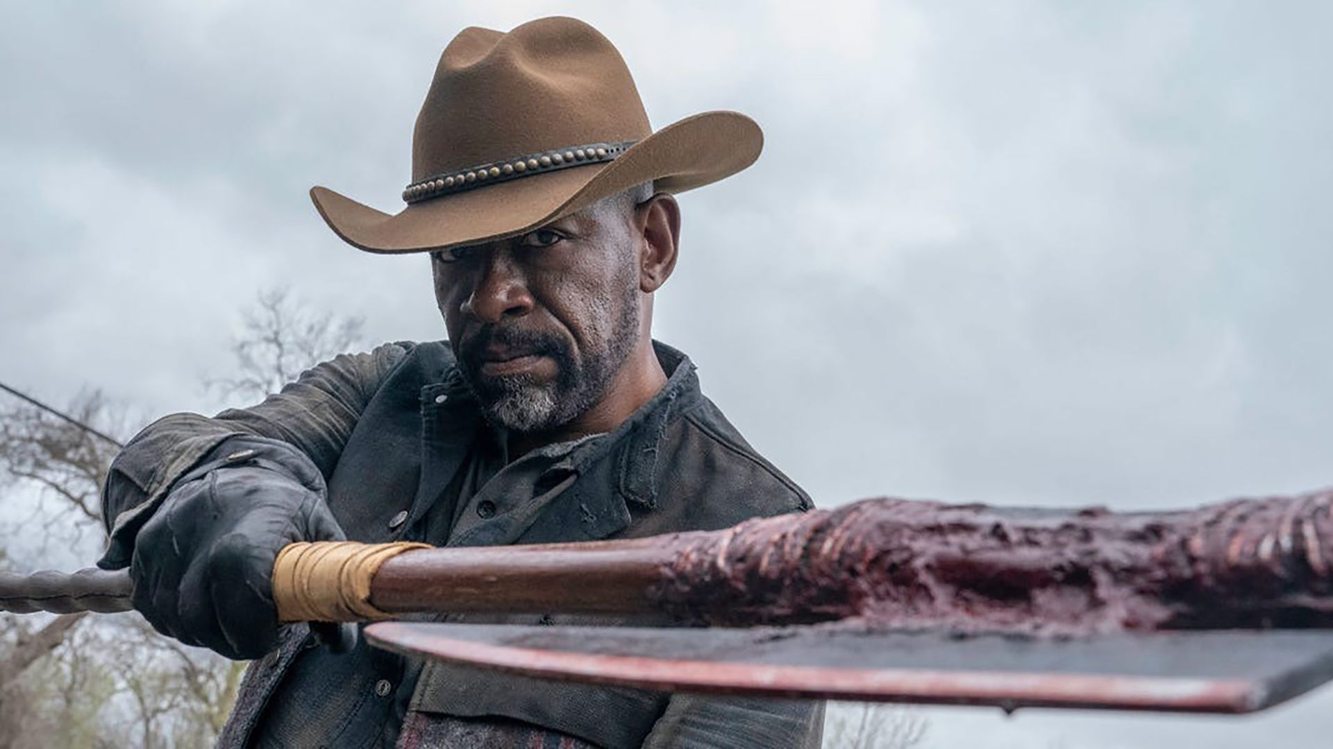 Morgan wearing a cowboy hat and holding out on ax in Fear the Walking Dead