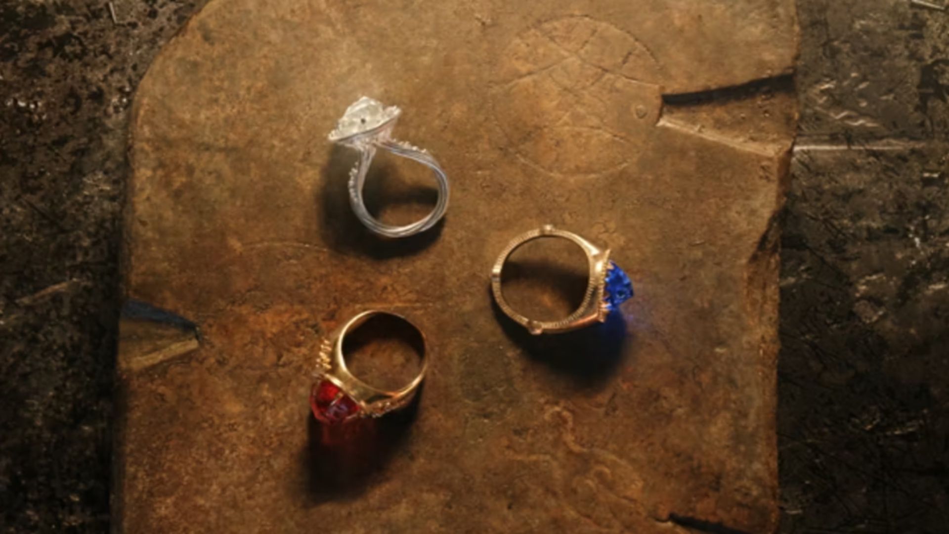 Three rings of power set out on a table in The Rings of Power