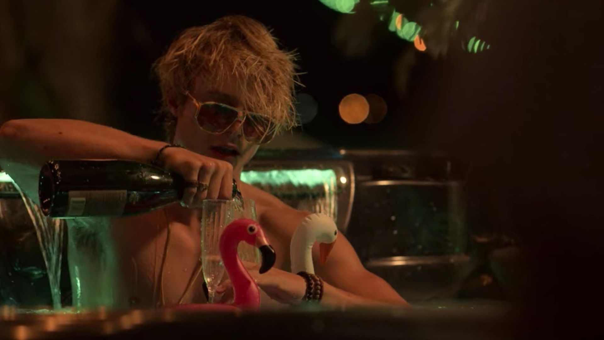 Rudy Pankow as JJ Maybank pouring a drink while in a hot tub in Outer Banks