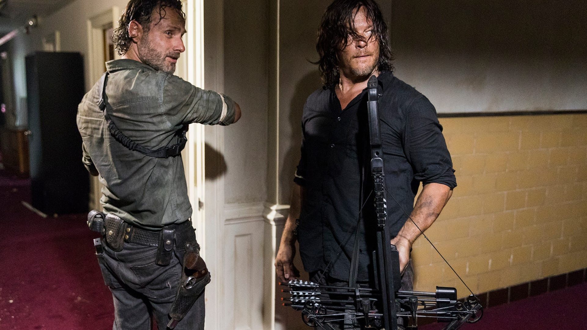 Rick and Daryl standing at a doorway on The Walking Dead, looking alert