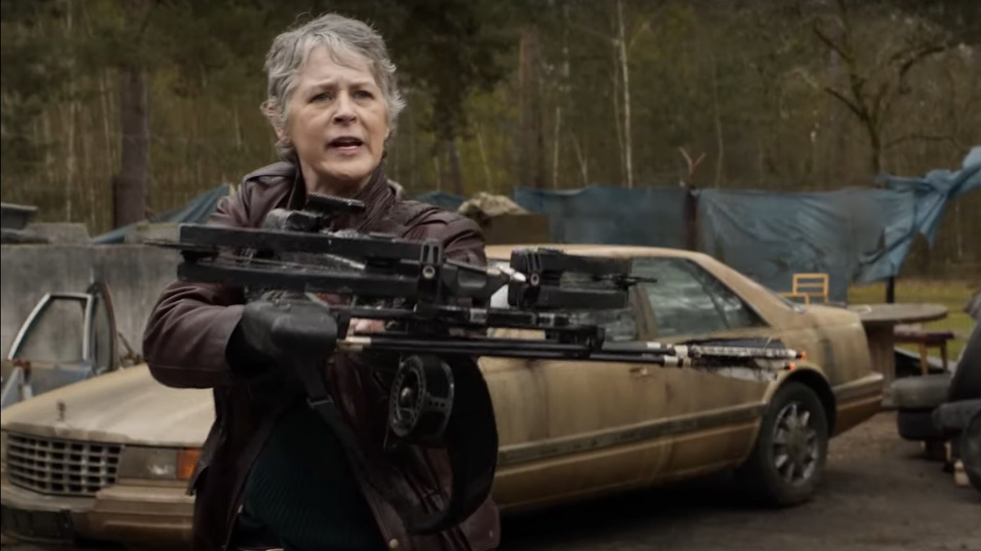 Melissa McBride as Carol aiming her bow in a scene from The Walking Dead: Daryl Dixon The Book of Carol