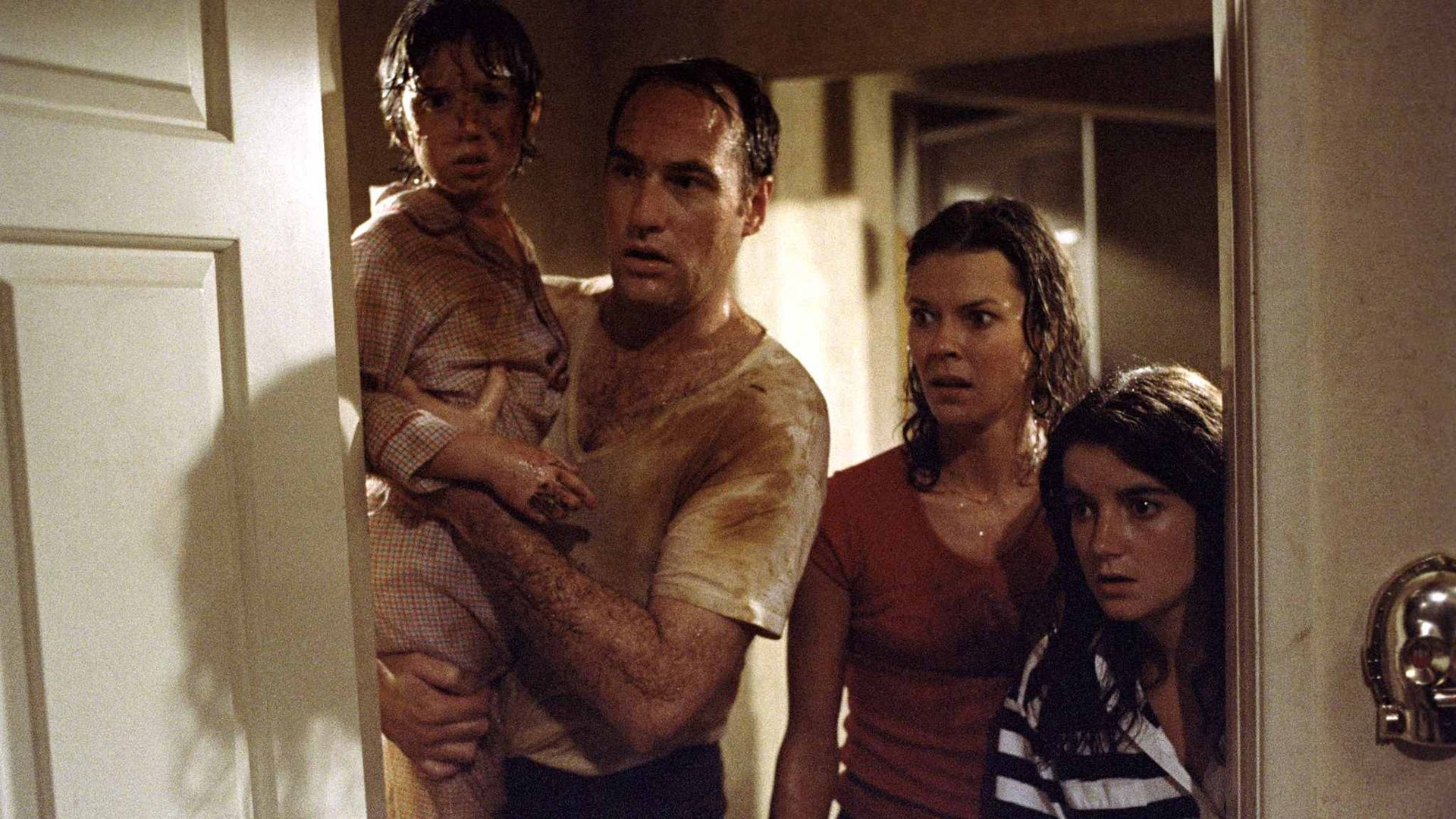 A family is dirty and sweaty hiding behind a door in Poltergeist.