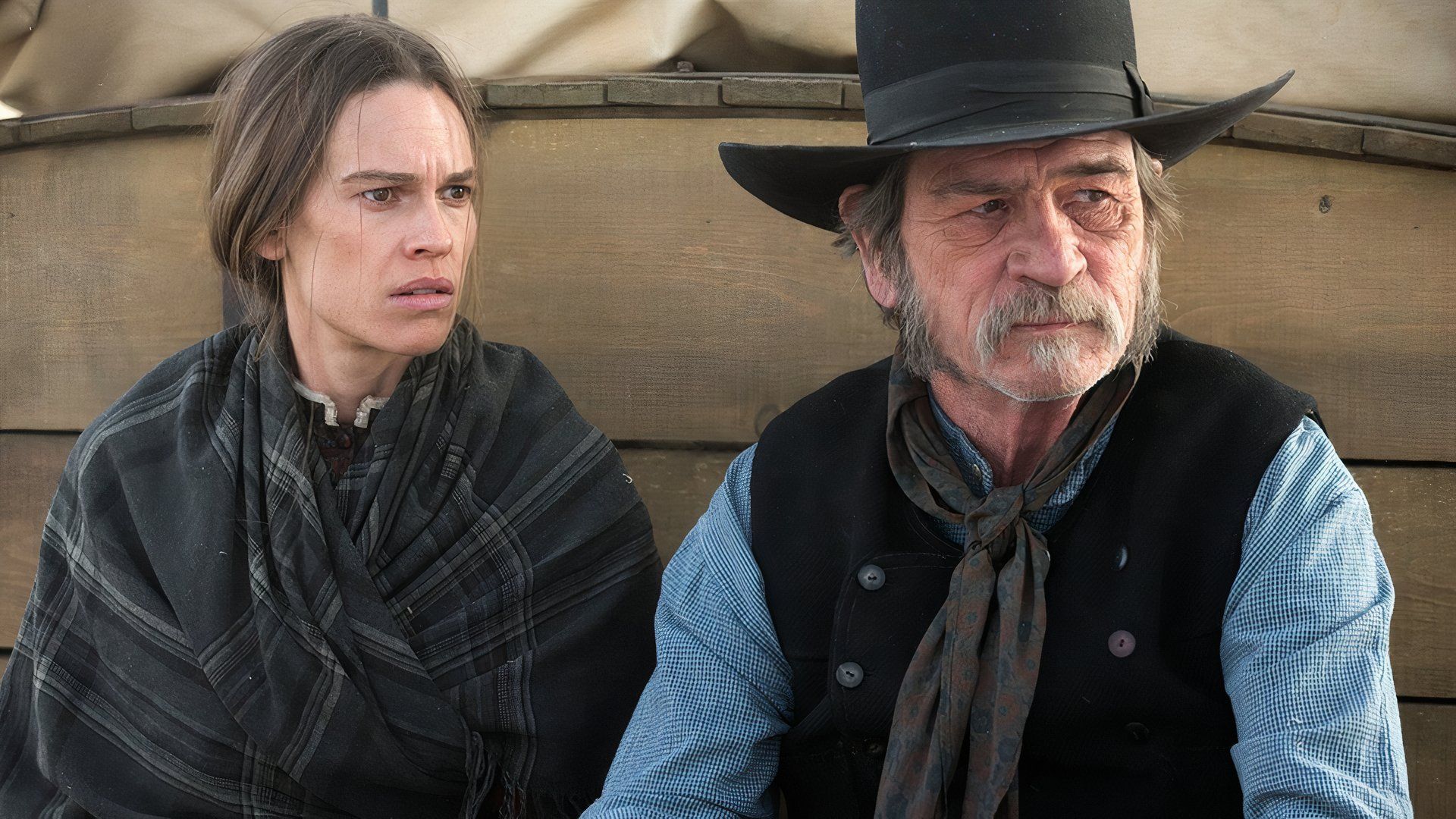 Mary and George sitting on a wagon in The Homesman