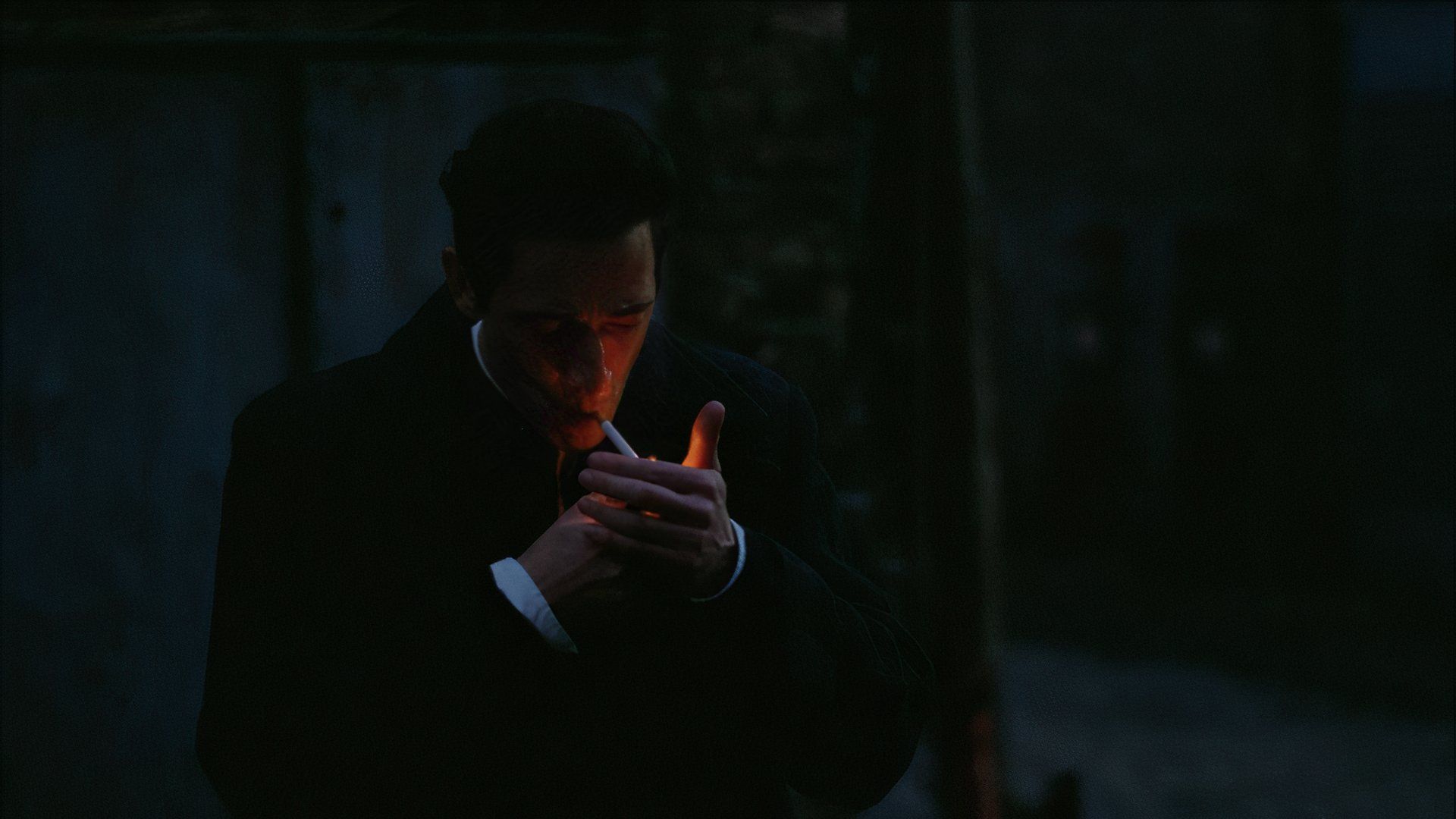 Adrien Brody lights a cigarette in The Brutalist movie