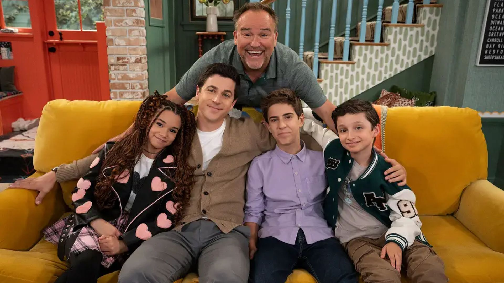 Jerry and Justin pose with kids on the couch in Wizards Beyond Waverly Place