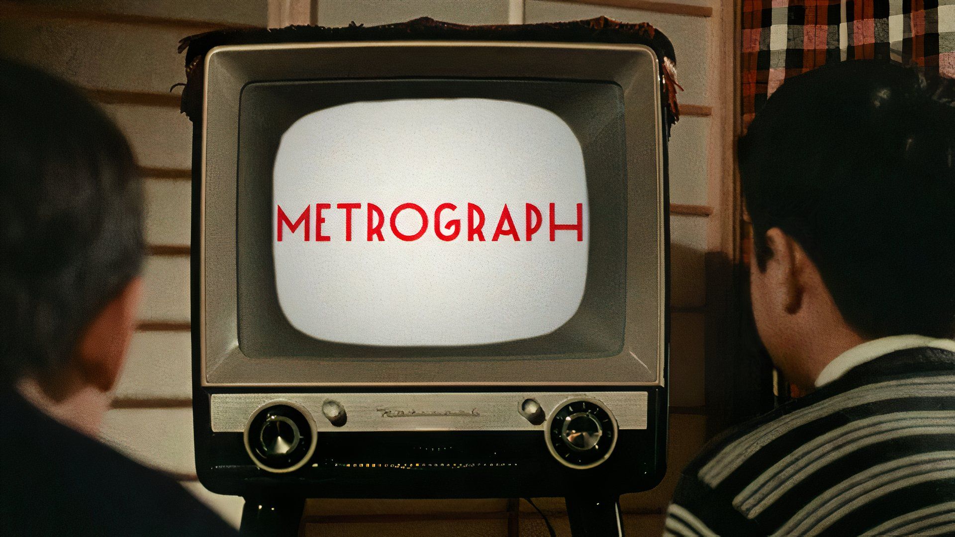 Kids watch an old TV with the word Metrograph on it