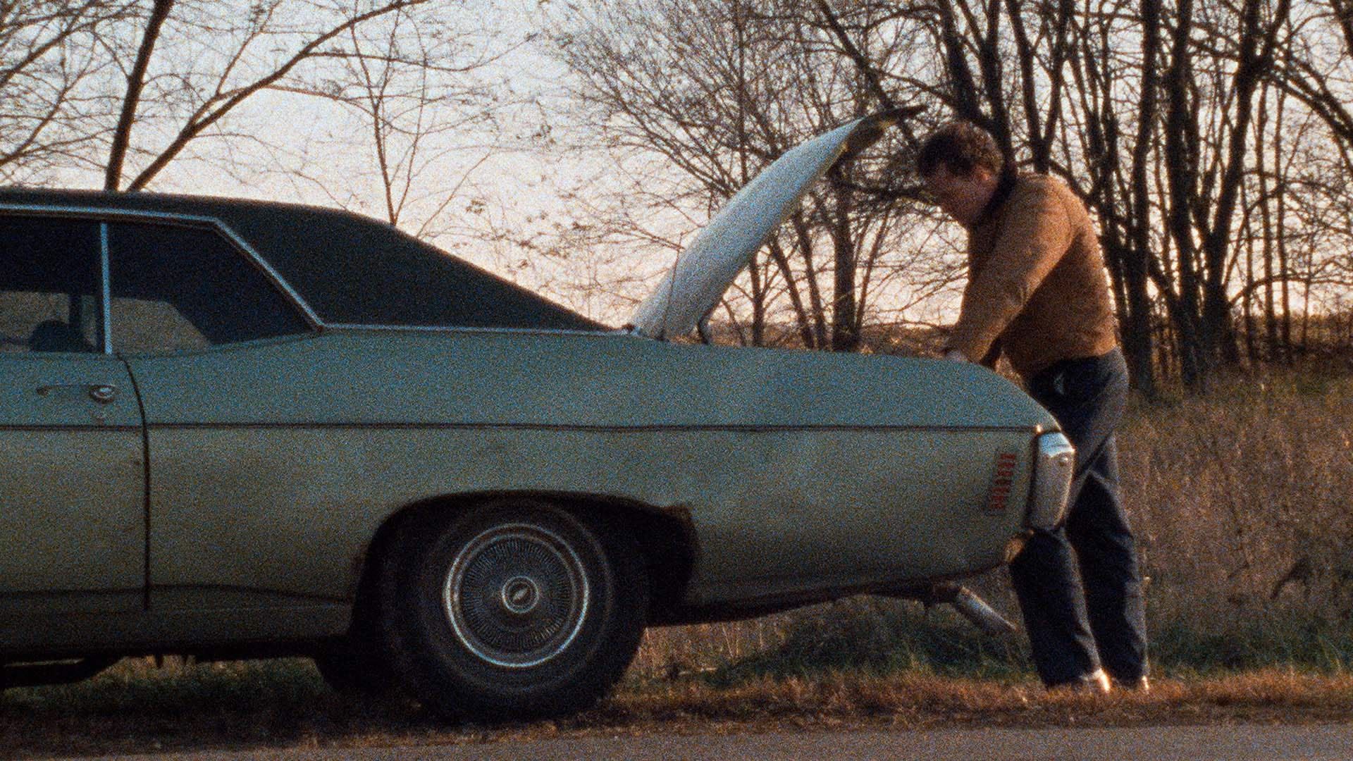 Henry looks in his car's trunk in Henry: Portrait of a Serial Killer