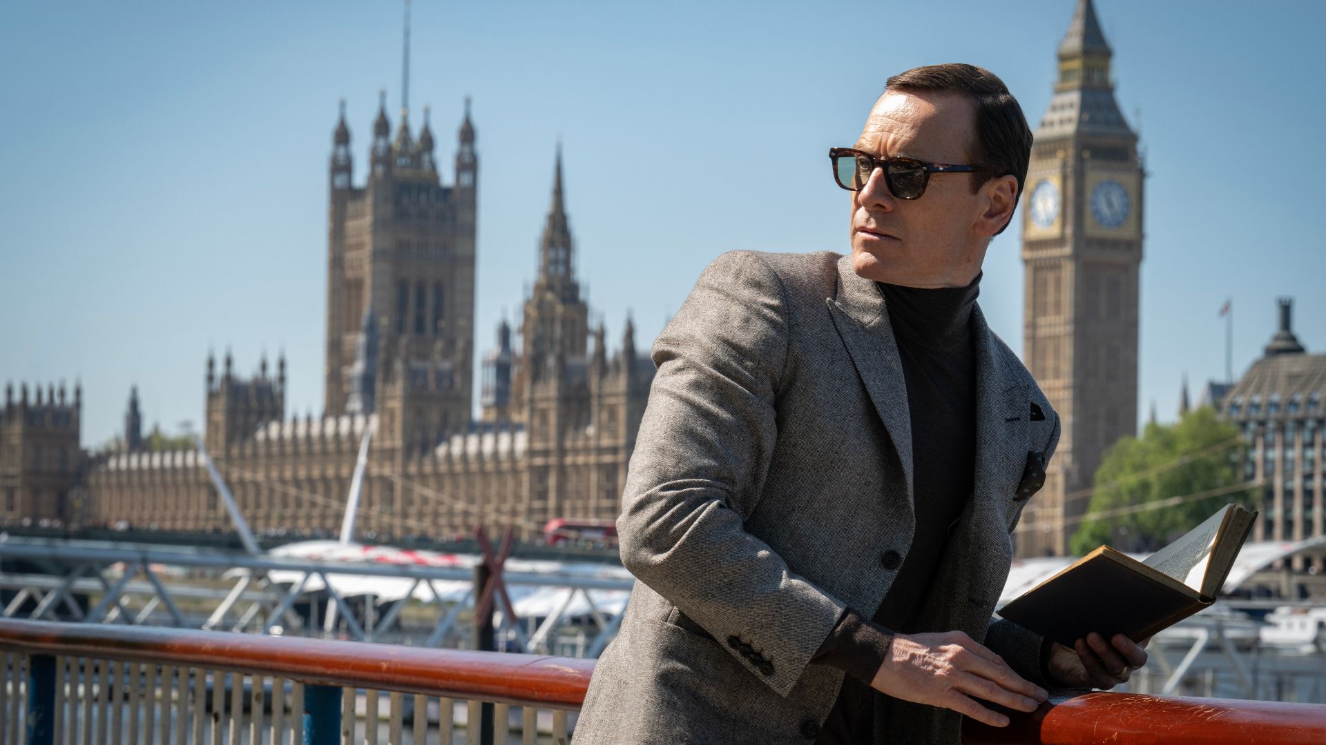 Michael Fassbender as George the spy in London with a book in 2025 movie Black Bag