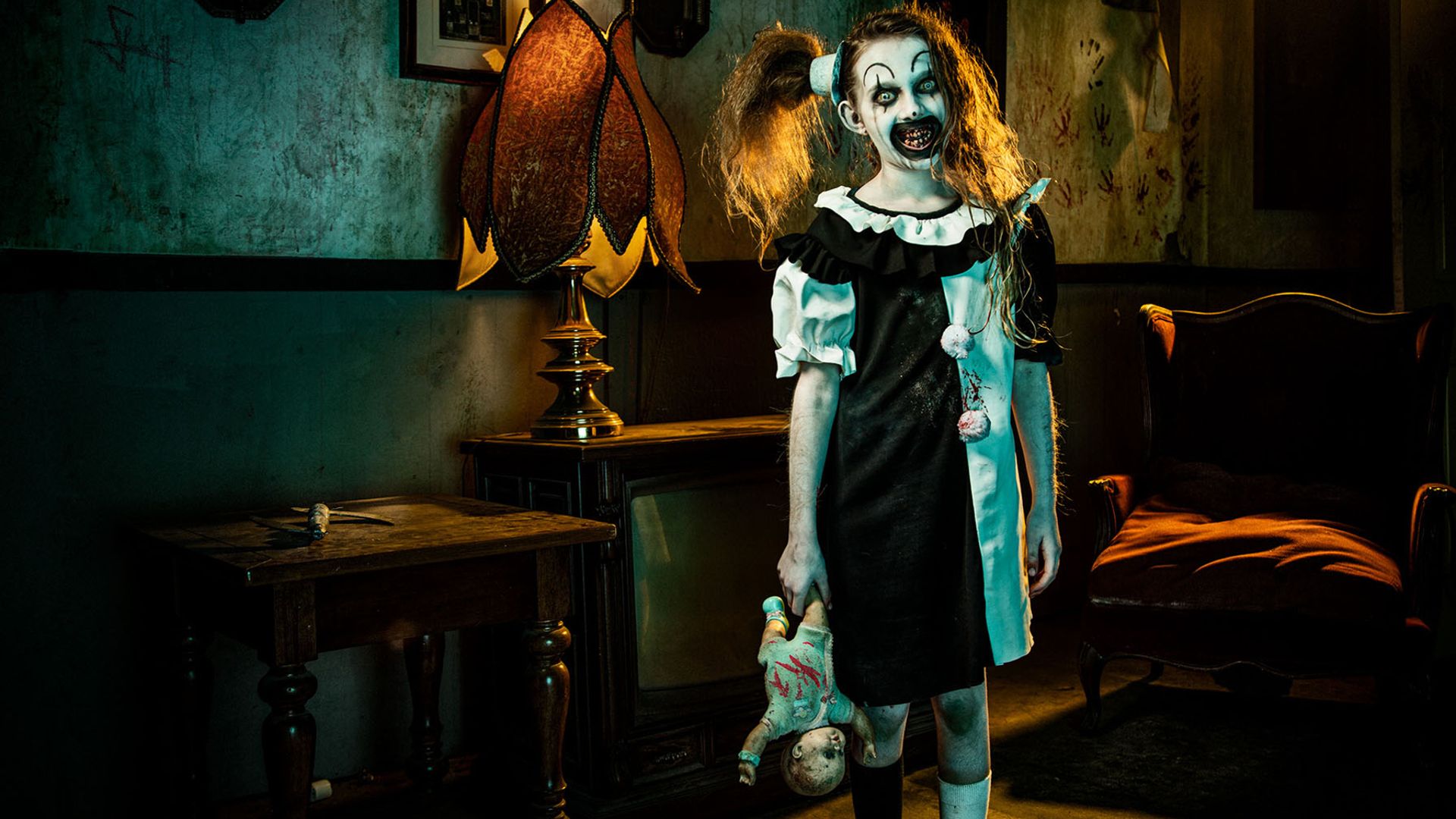 The pale girl holds a doll in Terrifier 2