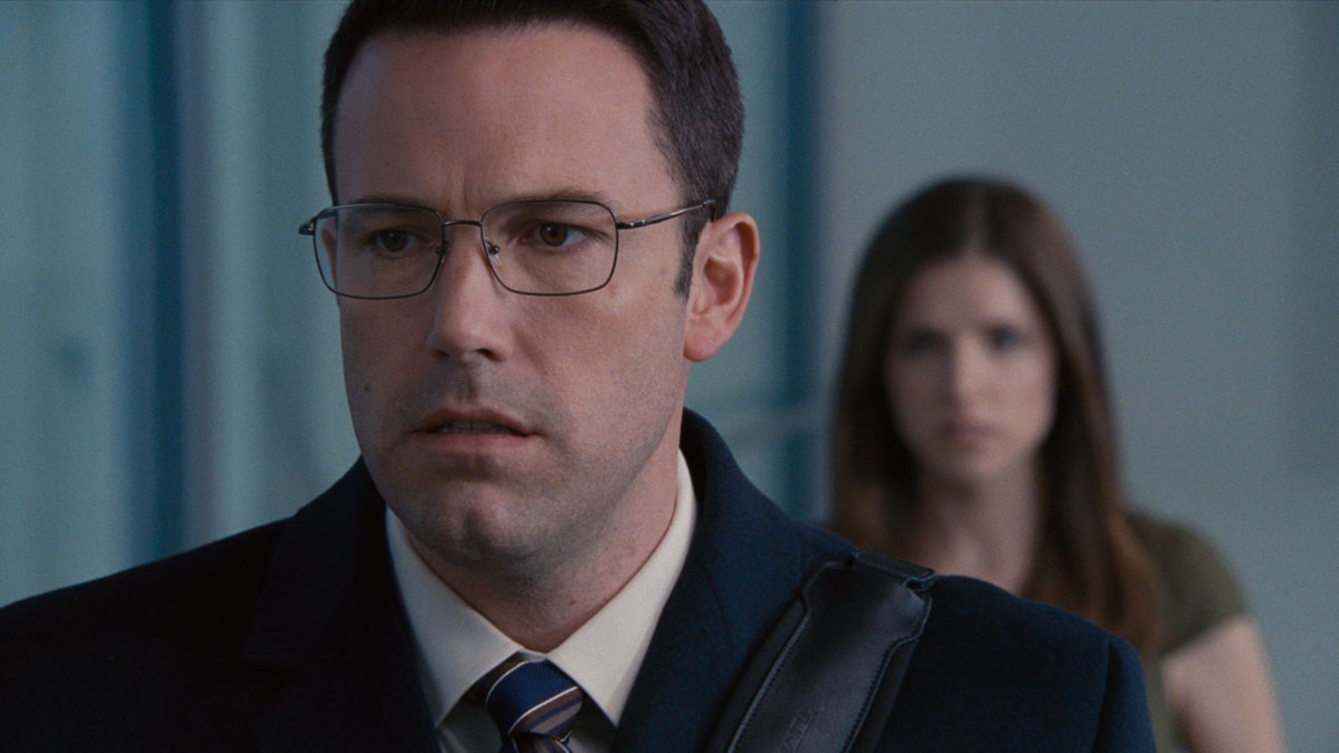 Ben Affleck in The Accountant wearing a suit jacket and glasses