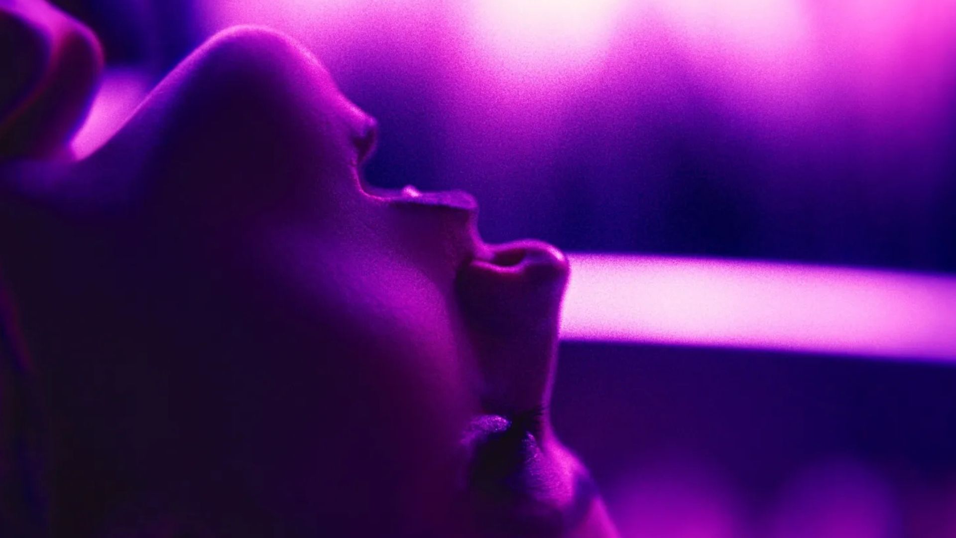 The upside down face of a woman in pleasure in purple light in the movie Touch Me