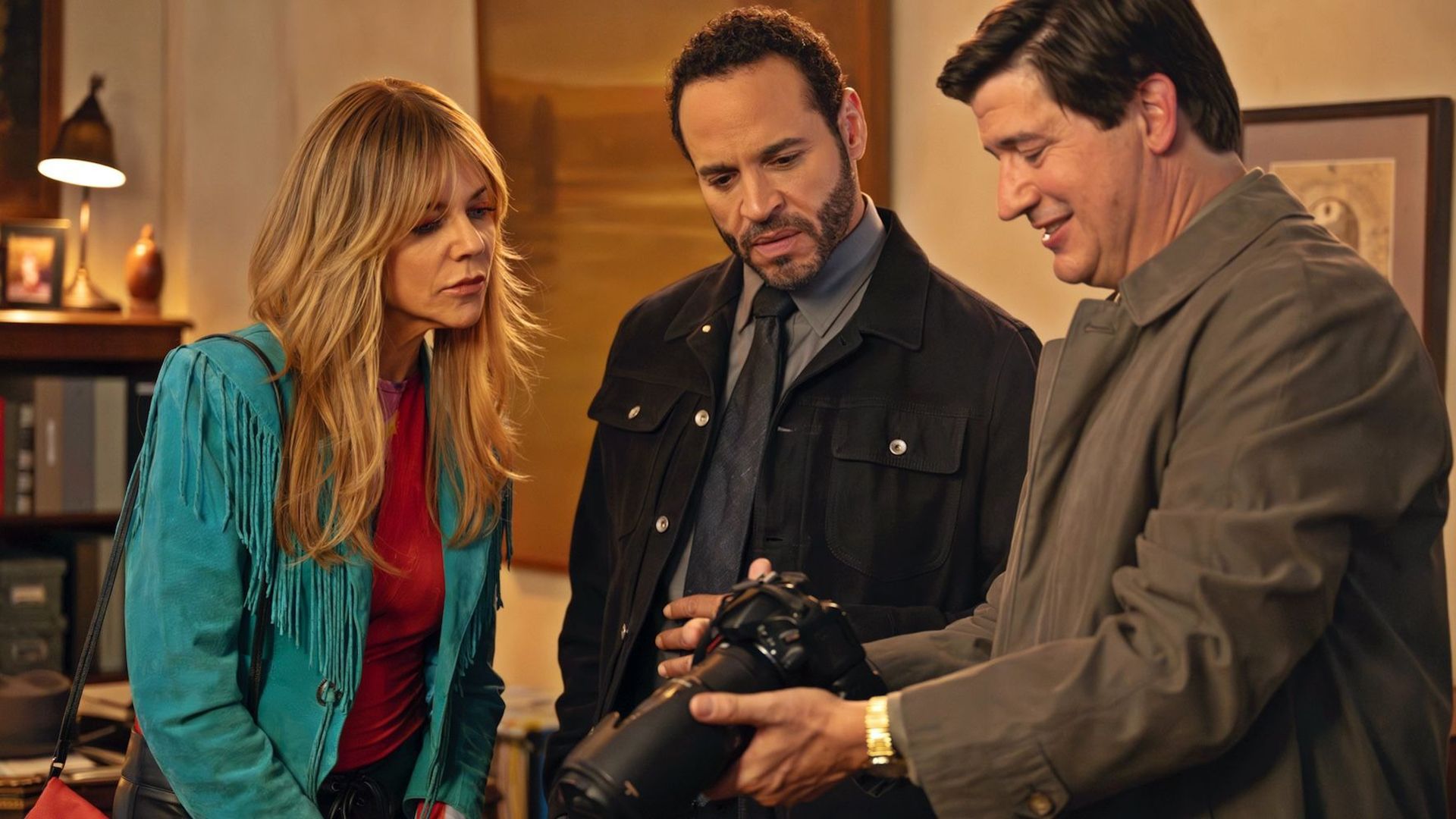 Chuck showing Morgan and Karadec photos from his camera in High Potential.