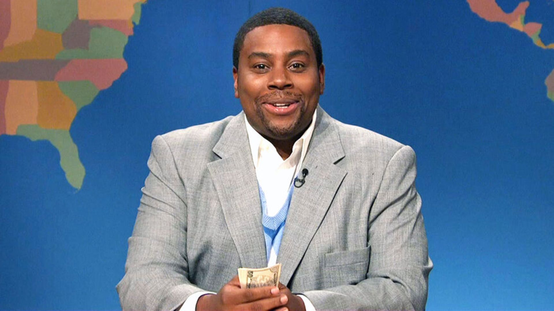 Kenan Thompson sits at the SNL news desk