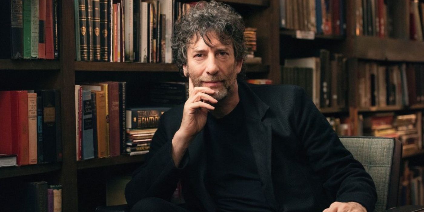 Neil Gaiman sitting in front of a bookshelf.