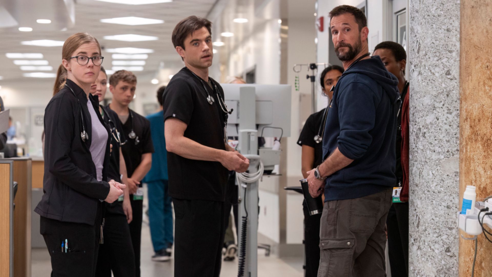 Robby stands in the hall with colleagues in The Pitt