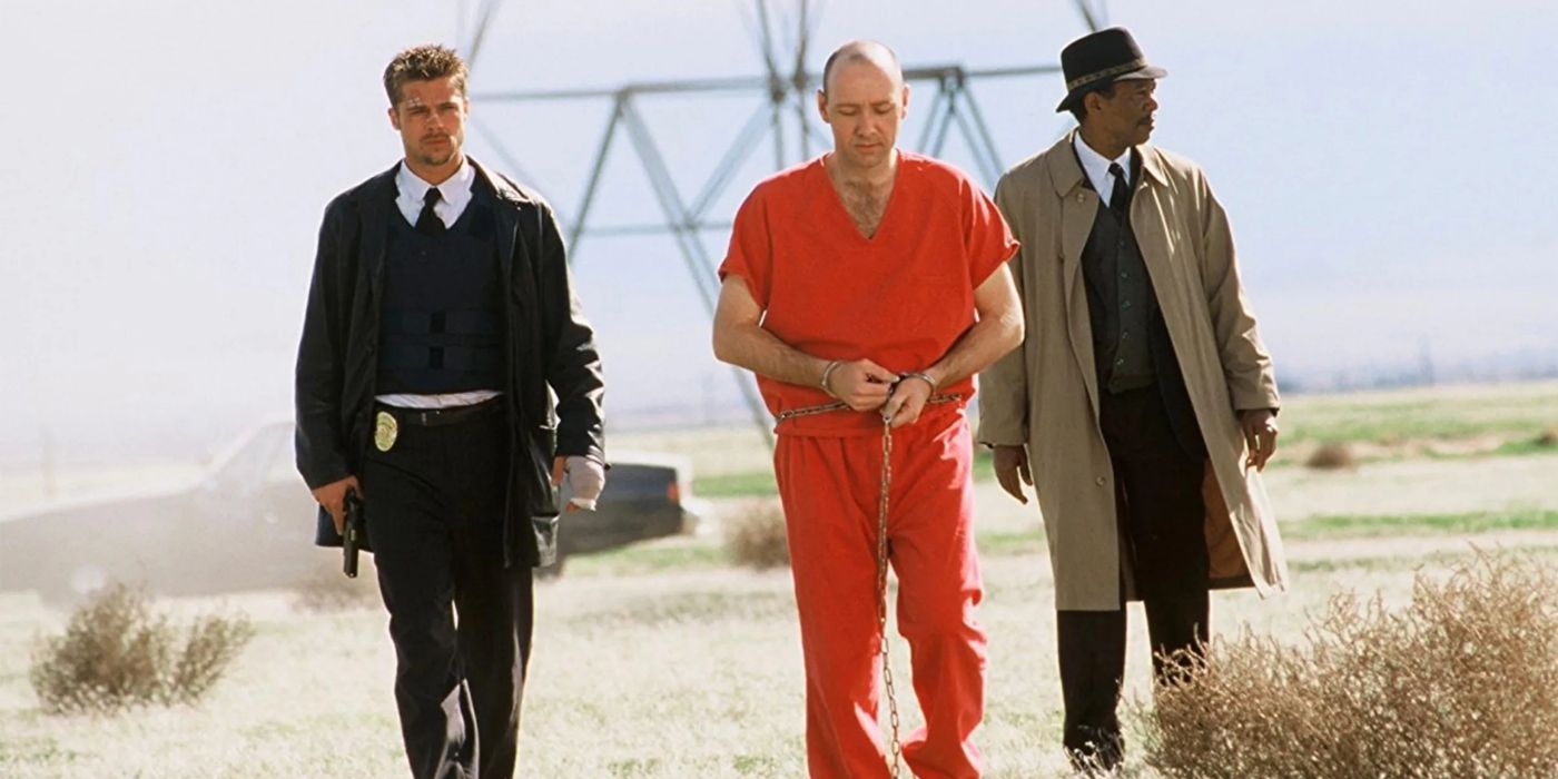 two detectives walk with a man in shackles in se7en