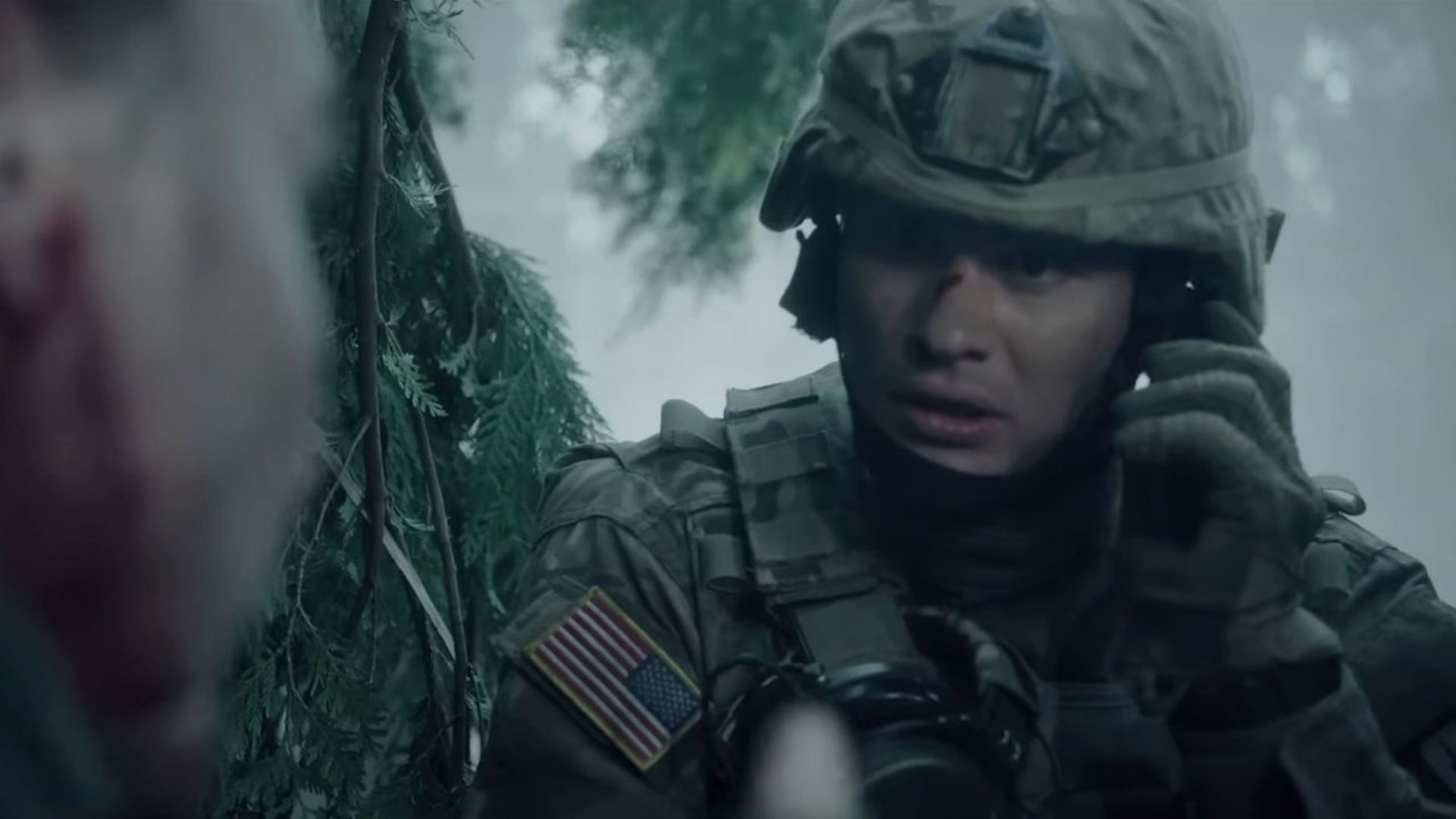 Chase Stokes in Valiant One using a radio in a military uniform