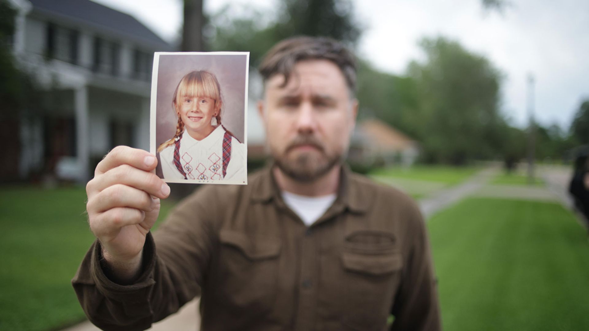 A man holds a picture of a girl in The Secret of Me