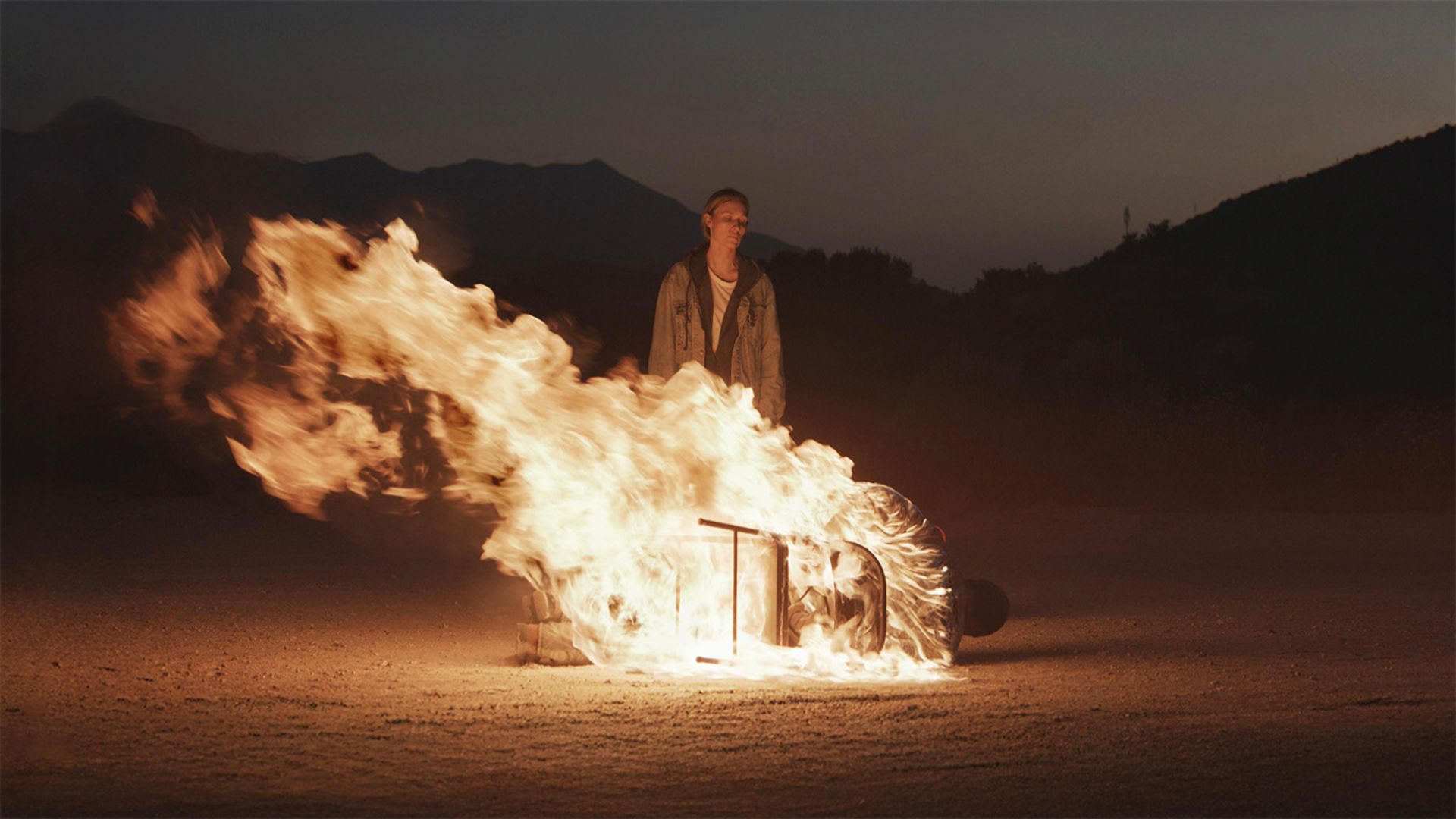 A man tied to a chair on fire tipped over in the desert in the movie Redux Redux