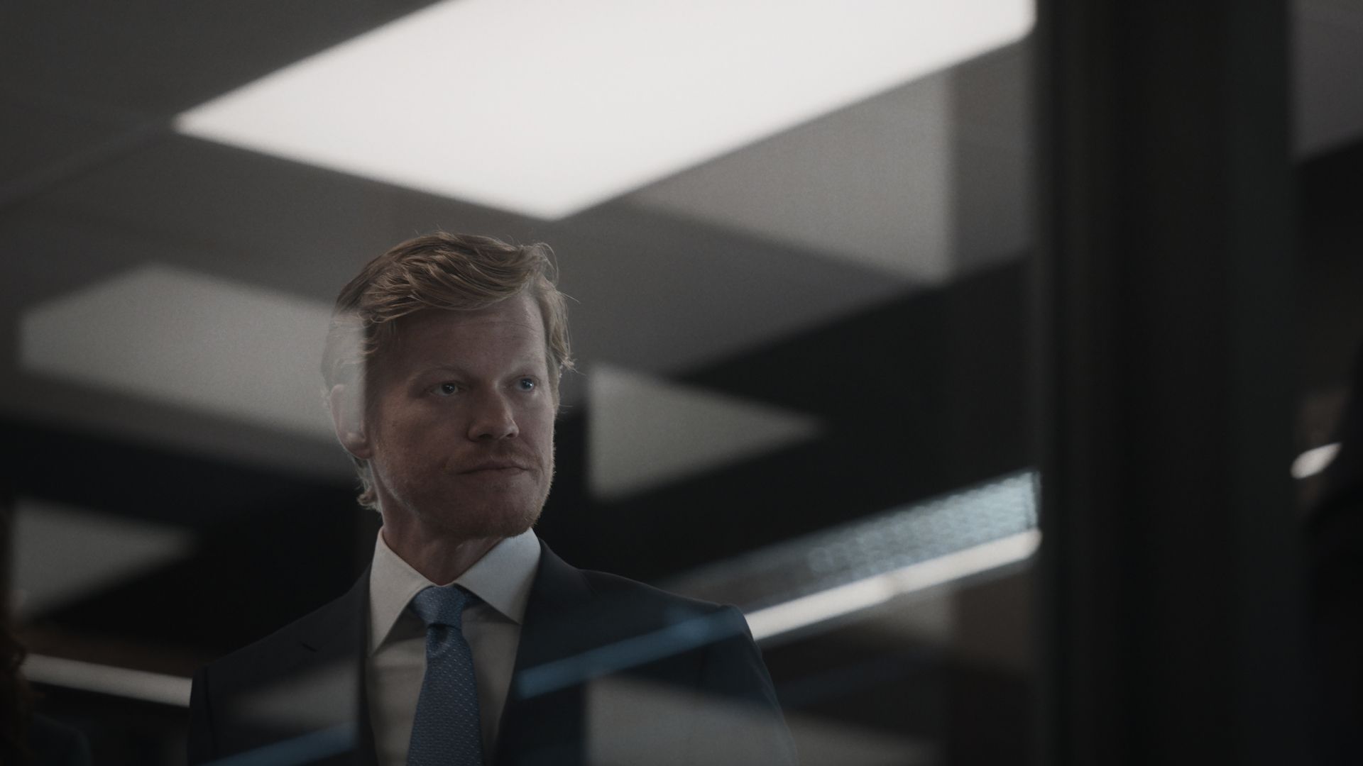 Jesse Plemons as Roger Carlson in a glass office in the Netflix series Zero Day