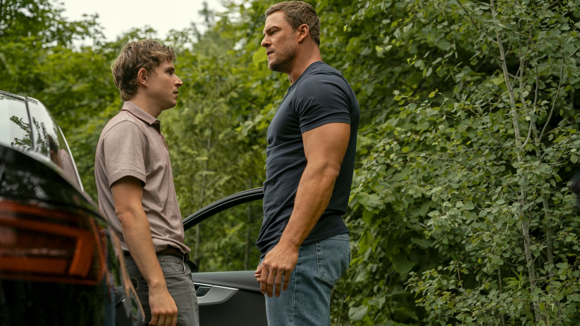 Johnny Berchtold (Richard Beck), Alan Ritchson (Jack Reacher) look at each other outside a car in Reacher