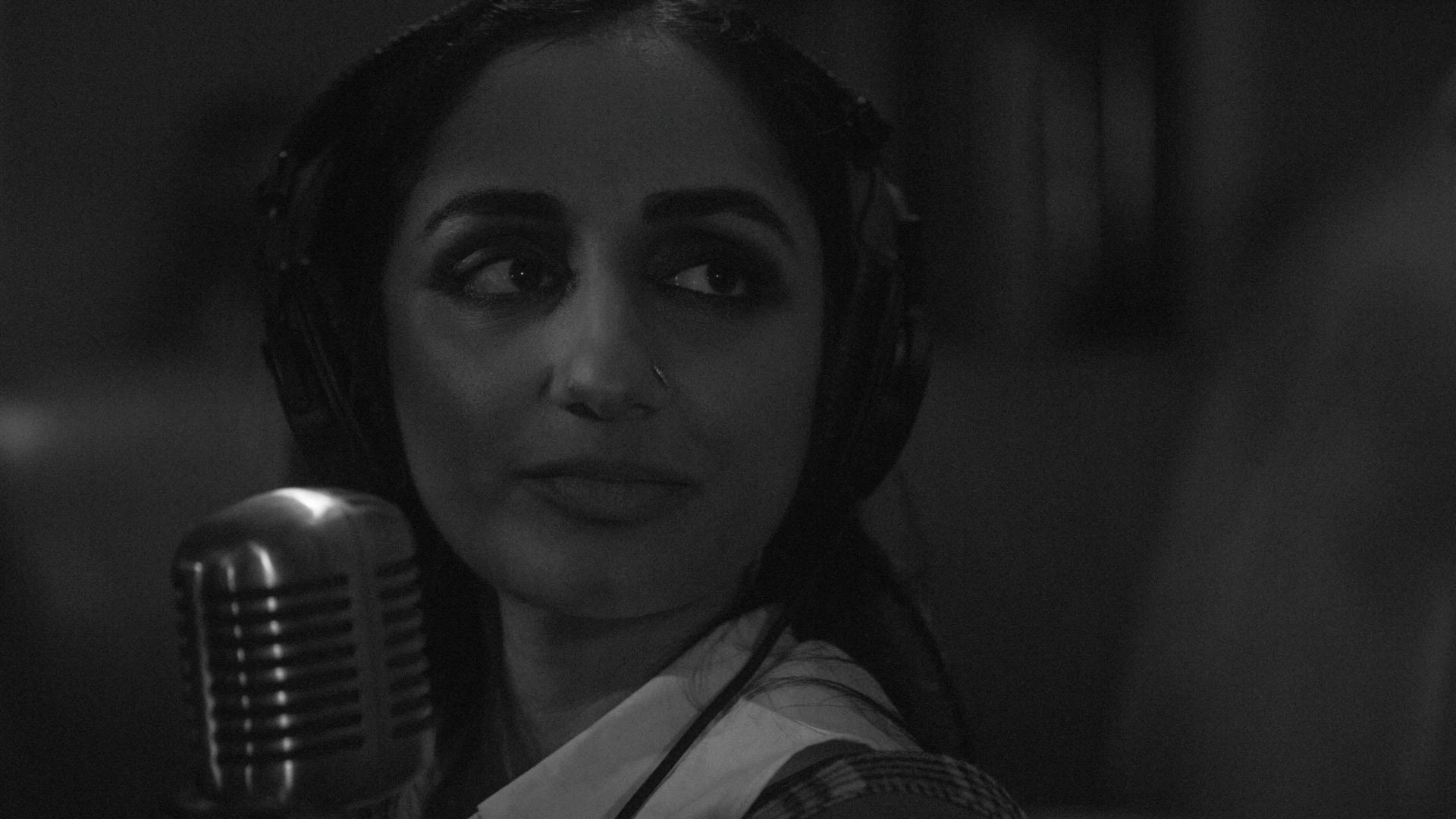 Vinita (Kiran Deol) with a microphone in the black and white 2025 Sundance movie Didn't Die