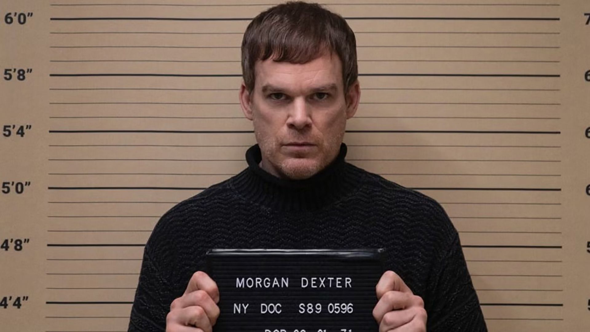 Dexter standing by a boar for his mugshot on Dexter: New Blood.