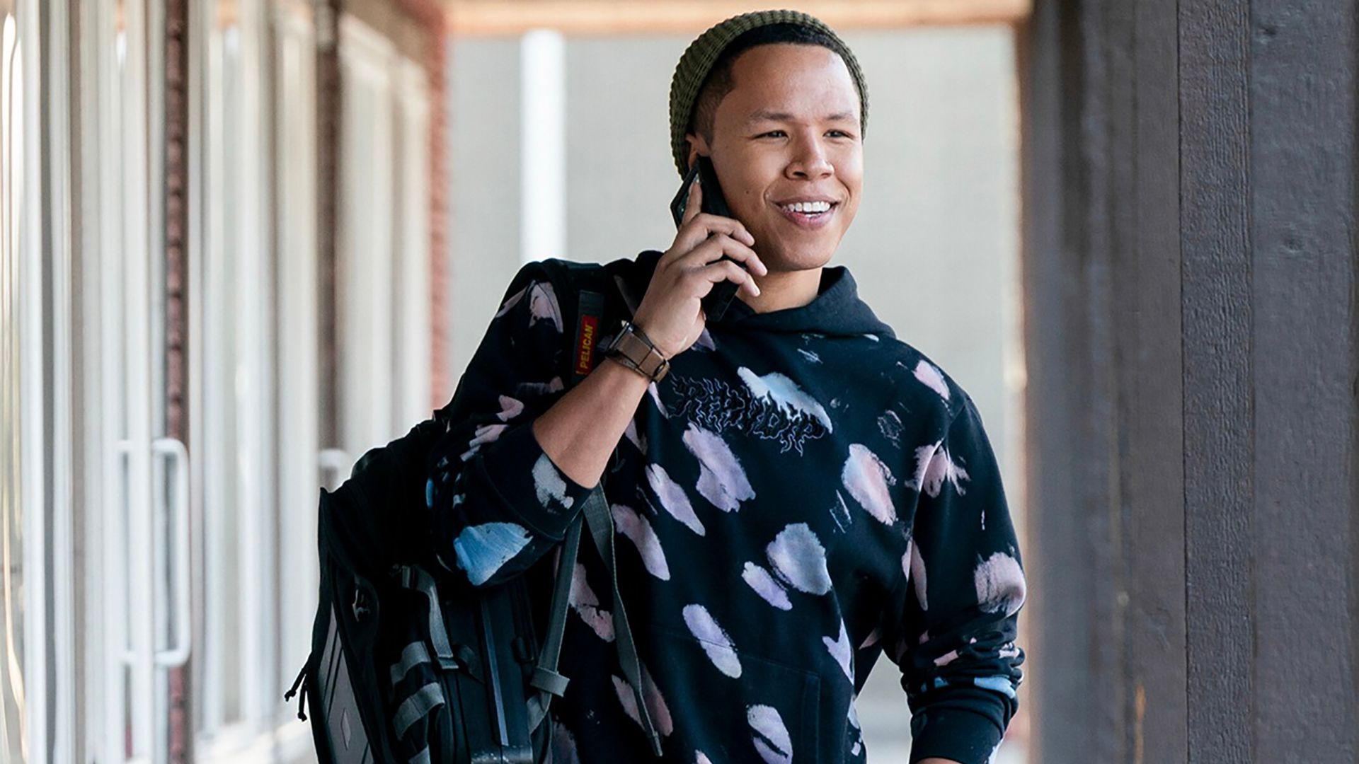 Bobby outside smiling while talking on the phone in Tracker.