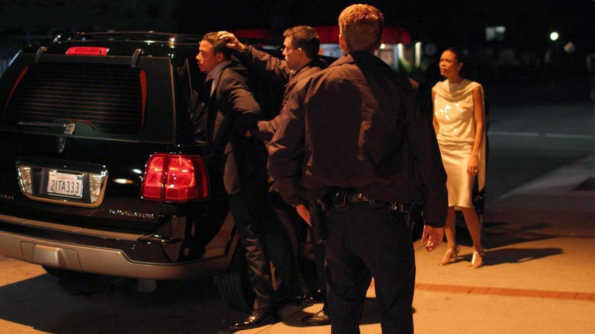 Ryan Phillippe looks on as Matt Dillon presses Terrence Howard against a car and Thandiwe Newton looks on in anger in Crash