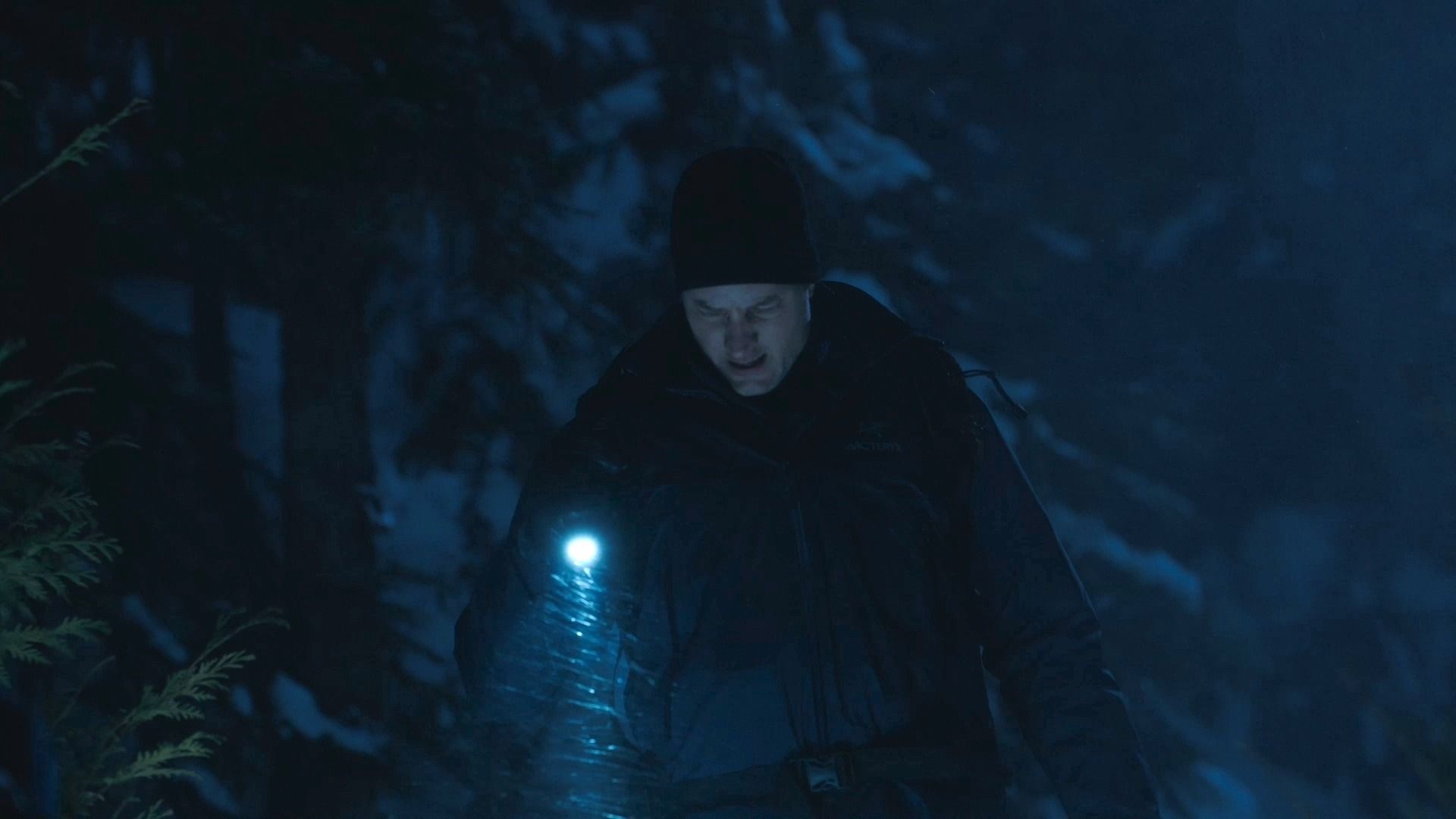 Colter wandering through the snow in the dark with a flashlight in Tracker