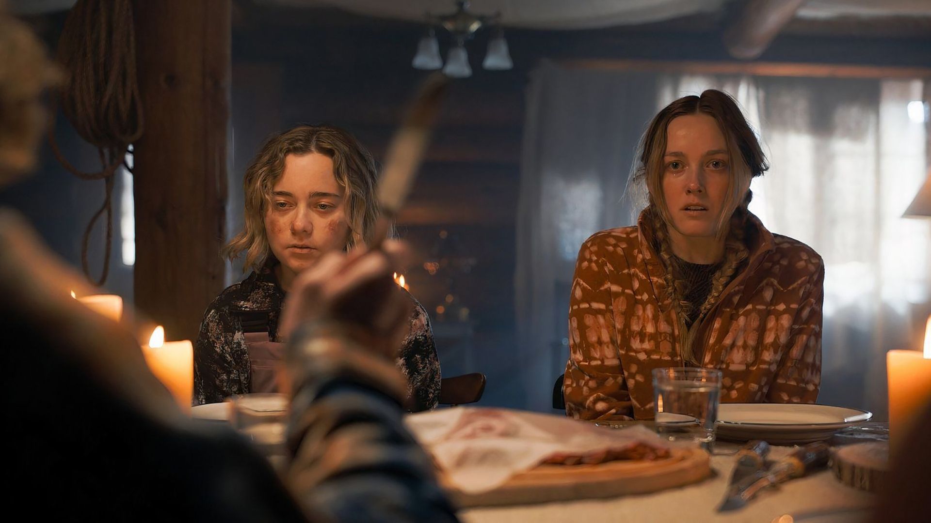 Shelly and Brianna looking terrified at the dinner table in Tracker