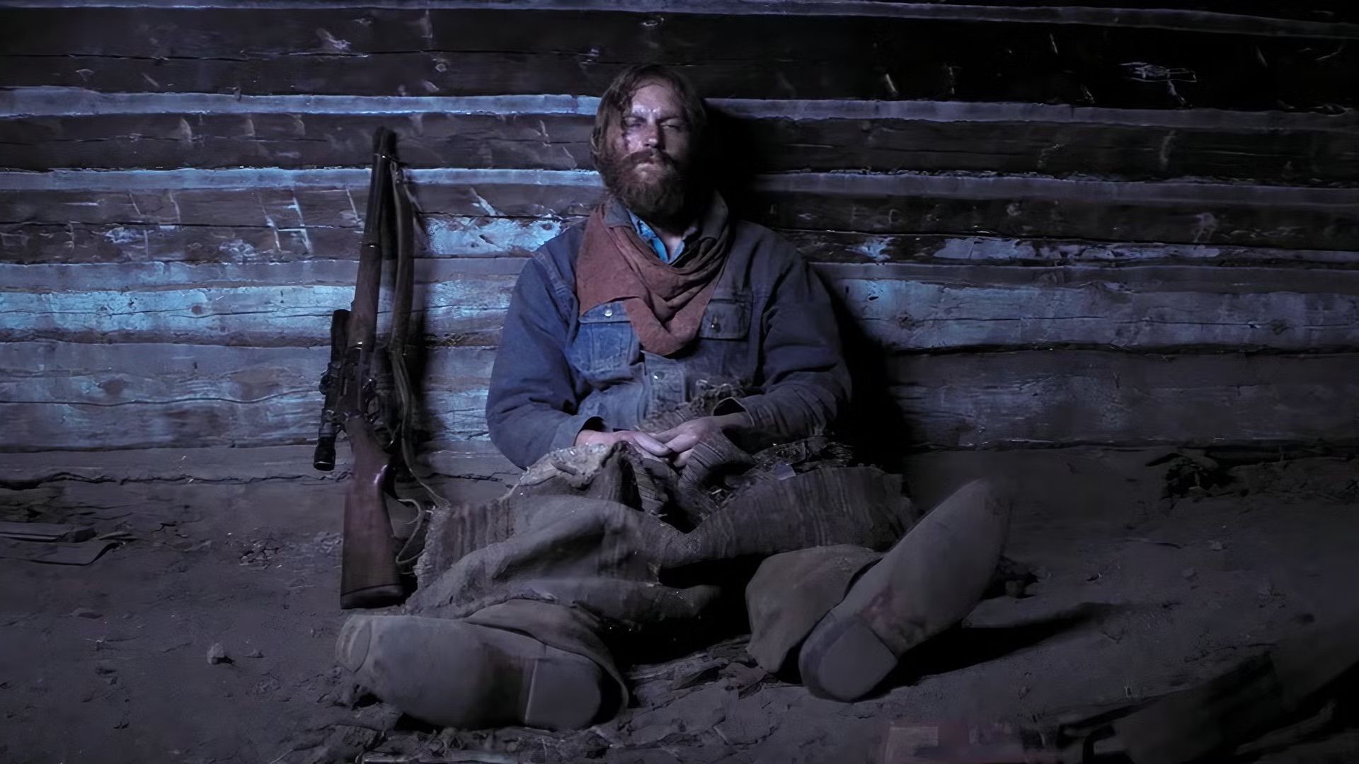 Wyatt Russell lays down hurt and exhausted next to his rifle in Broke