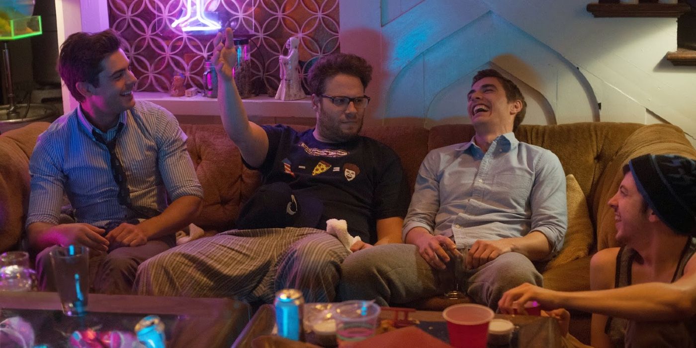 Zac Efron, Seth Rogen, Dave Franco and Christopher Mintz-Plasse sit on a couch at a party in Neighbors