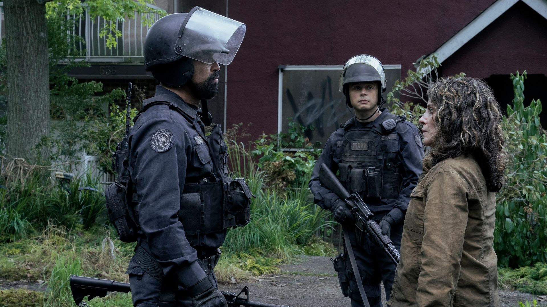 Jeffrey Wright as Isaac Dixon in FEDRA uniform talking to Alanna Ubach as Hanrahan in The Last of Us Season 2.
