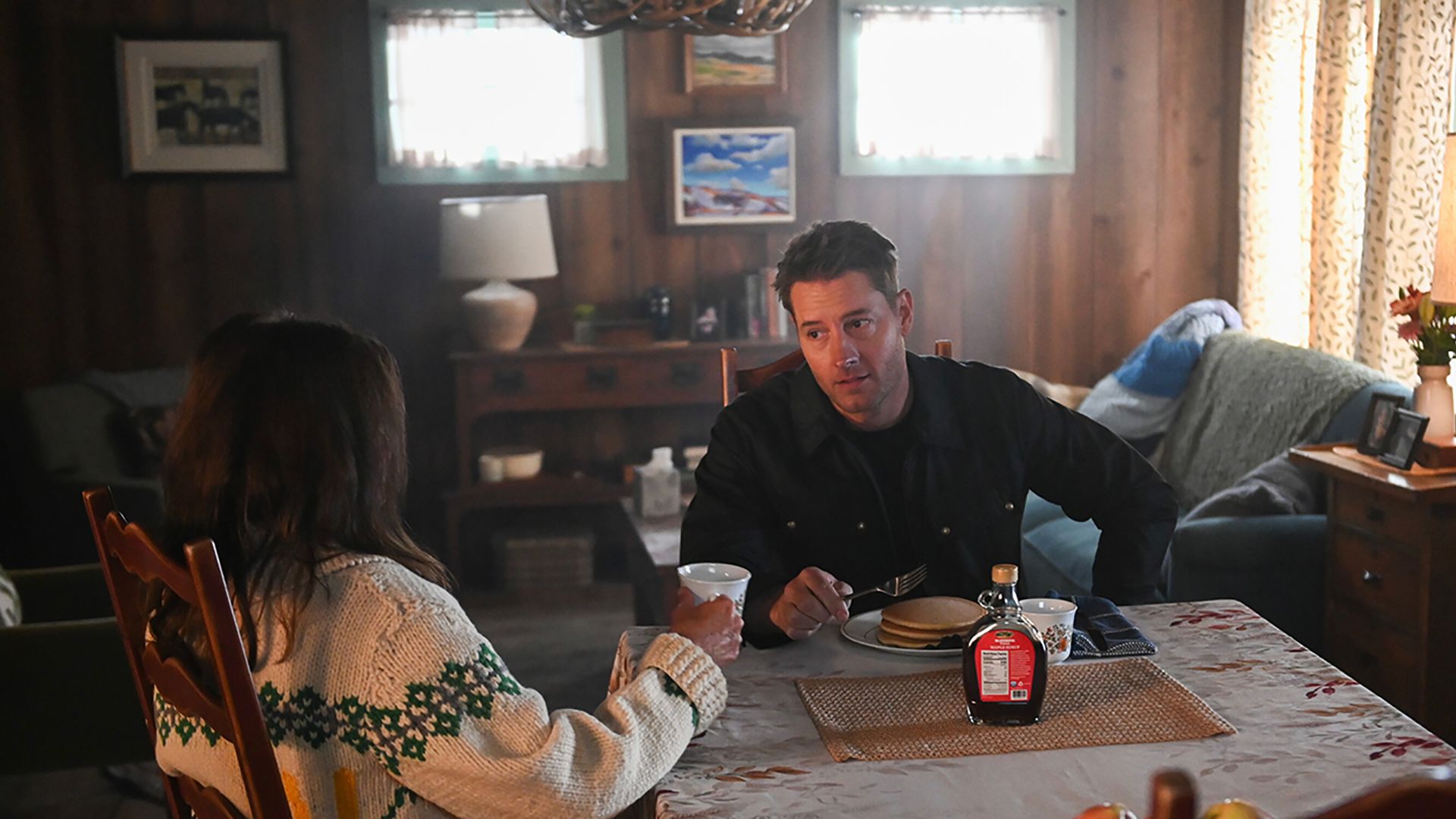 Colter eating pancakes while talking to his mother in her kitchen in Tracker.