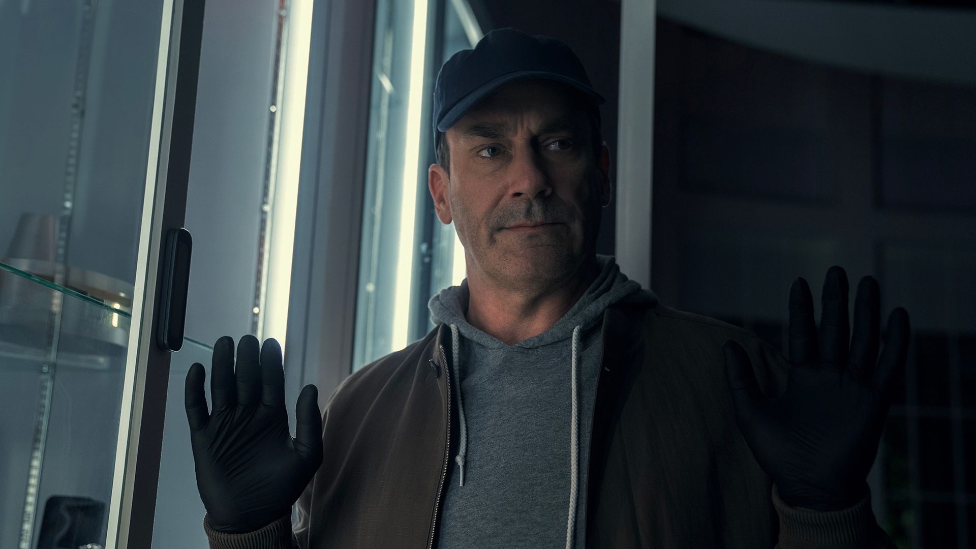 Coop wearing a baseball cap with his hands in the air in Your Friends & Neighbors