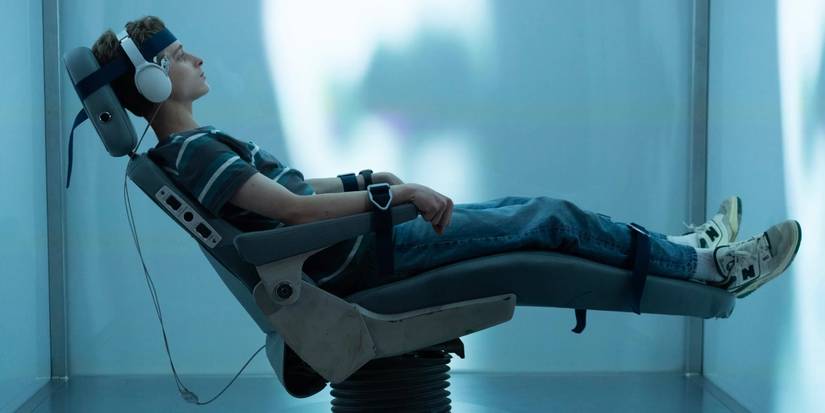 Joe Freeman in The Institute sitting in a chair with headphones on.