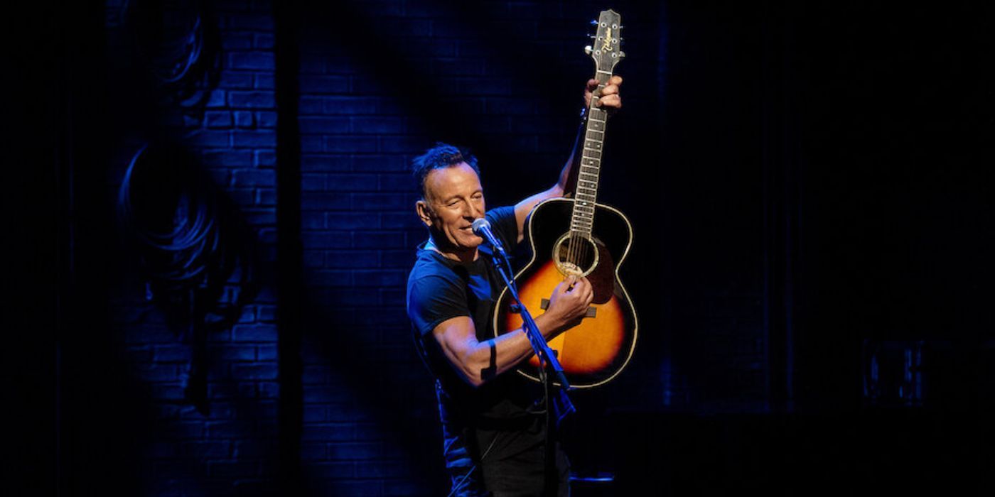 Bruce Springsteen raises his guitar in Springsteen on Broadway
