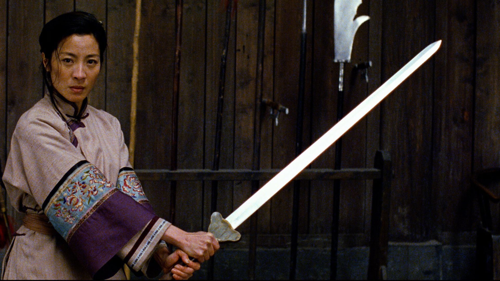 Yu Shu holds a sword by a gate in Crouching Tiger, Hidden Dragon