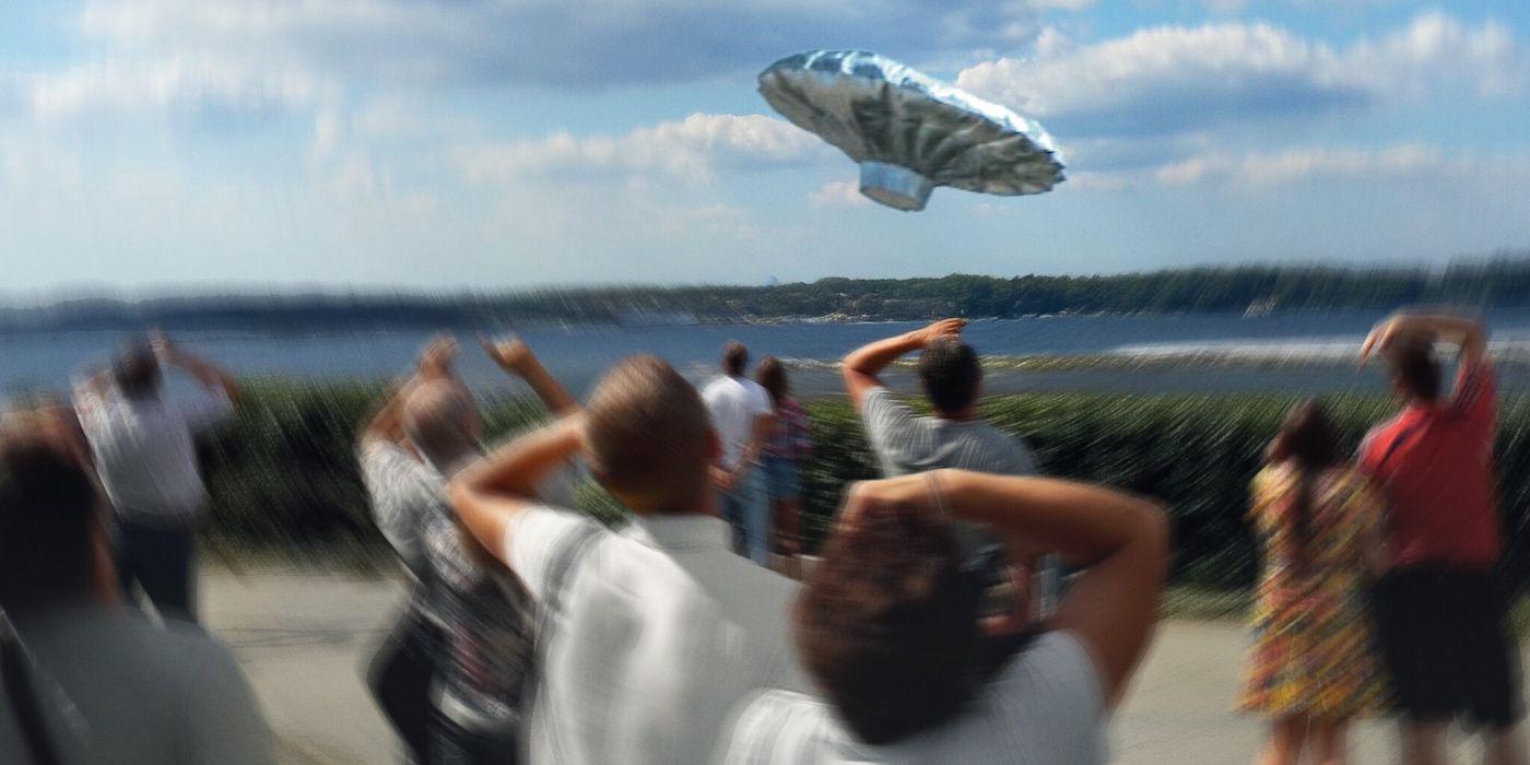 a group of people look up at a helium saucer in trainwreck balloon boy