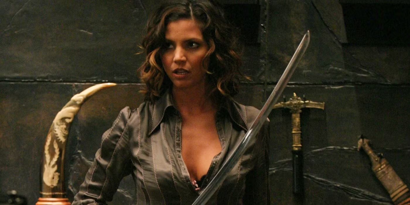Charisma Carpenter holds a sword in a gray shirt as Cordelia Chase on Angel