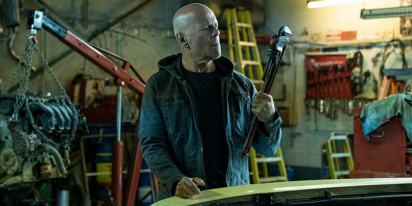 Bruce Willis in a garage holding a large pipe wrench in Death Wish 2018.