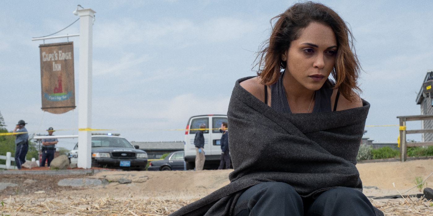 Jackie is wrapped in a blanket on the beach in Hightown