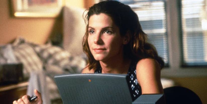 Sandra Bullock smiling in front of a computer in The Net