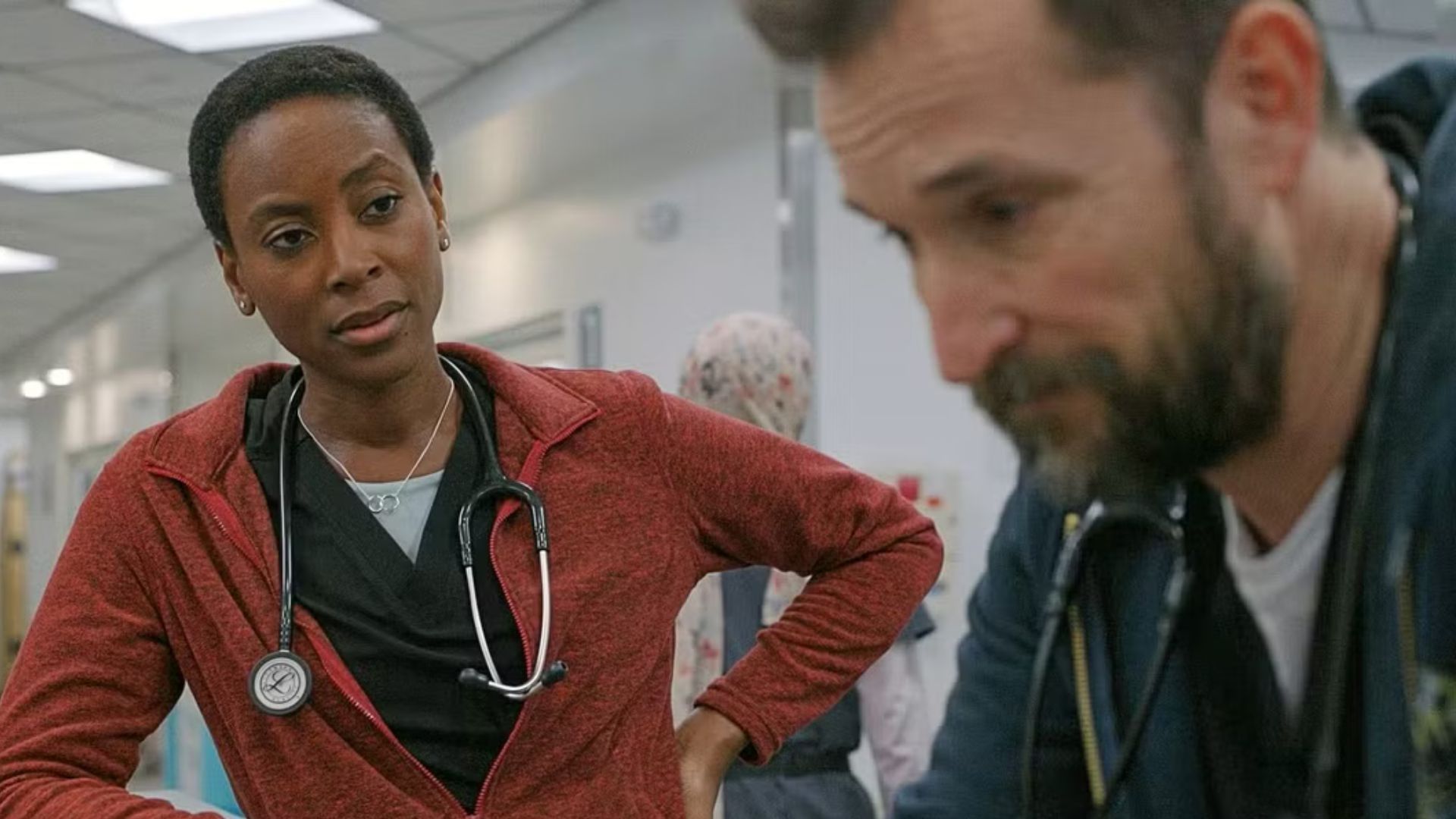 Dr. Collins talking to Dr. Robby with her hand on her hip in The Pitt.